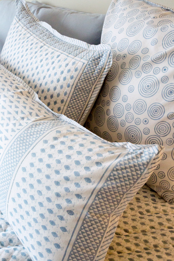 Close up on Herring Run collection pillows, print of small blue fish and bubbly circles